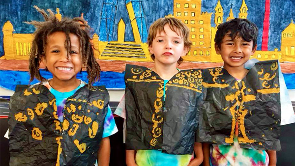 World Fiesta activity image depicting three diverse boys wearing their project ponchos.