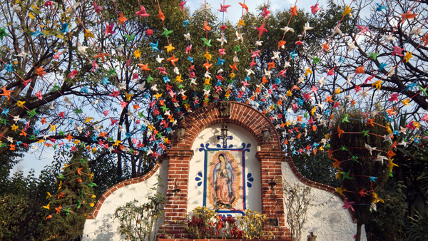 Our Lady of Guadalupe altar decorated with colorful pinwheels strung above